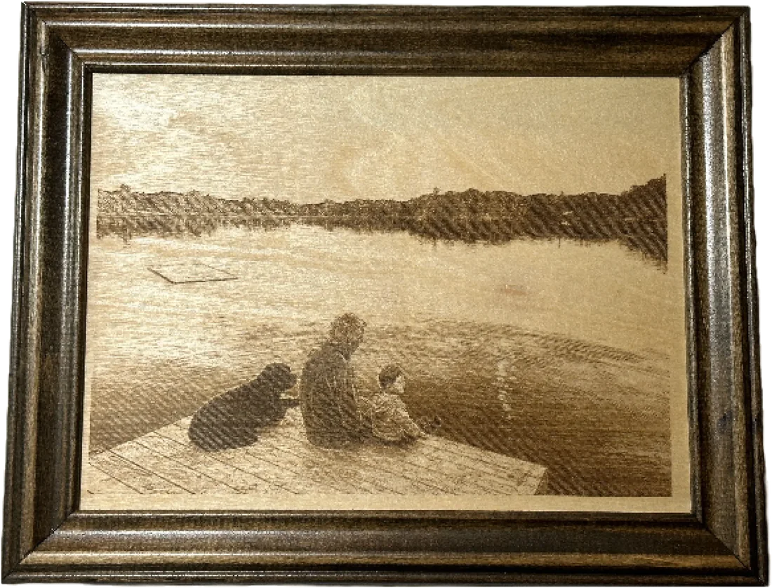 Laser-engraved photo of a person and dog on a dock by the lake, framed